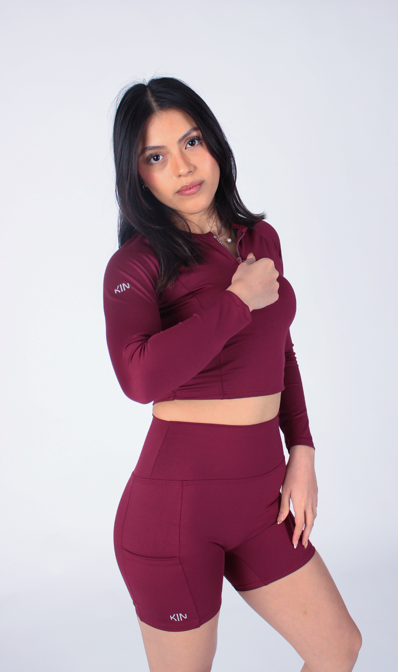 Mujer usando crop top de manga larga Merlot KIN Active en entrenamiento de otoño