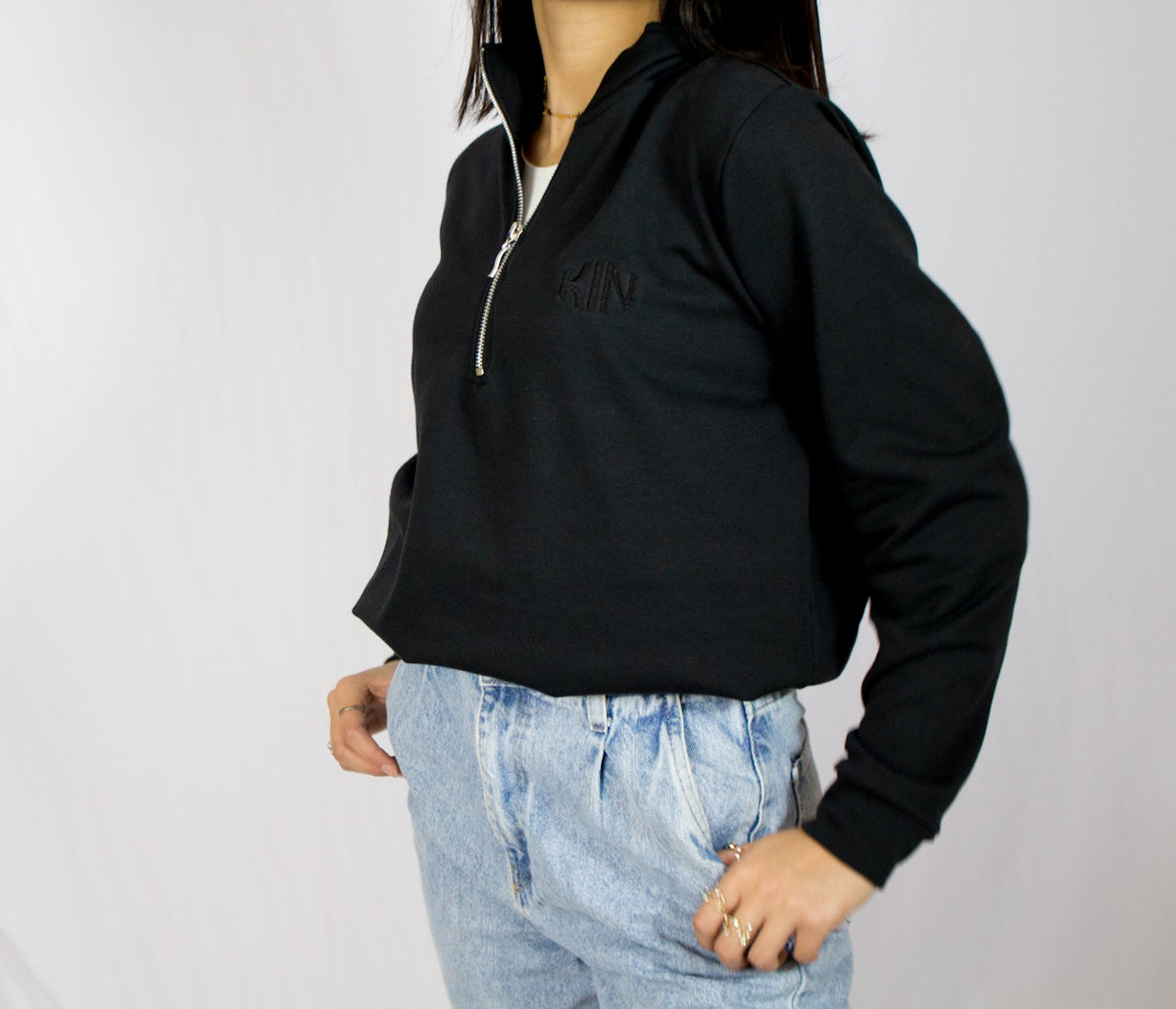 Detalle del cierre y textura de tela de la chamarra half zip Onyx KIN Active