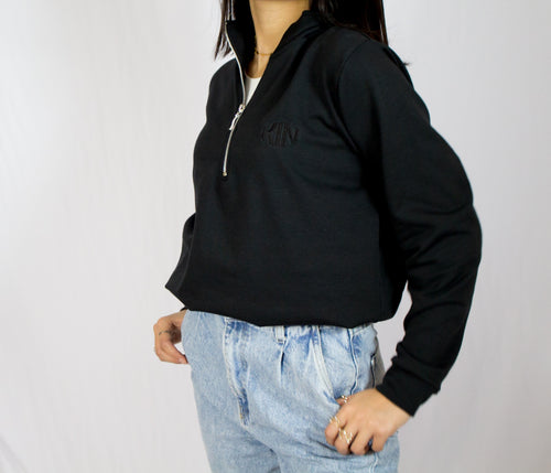 Detalle del cierre y textura de tela de la chamarra half zip Onyx KIN Active